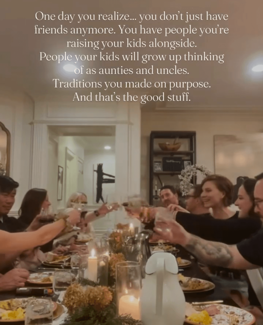 Friends and family toasting around a candlelit dinner table
